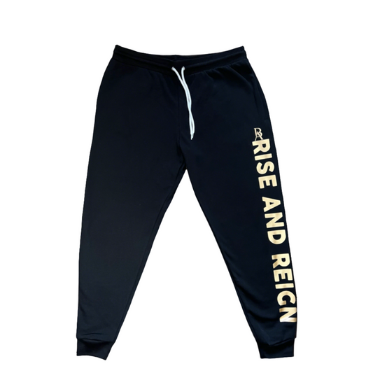 "Black 'Rise and Reign' joggers with gold print, featuring side pockets, ribbed ankle cuffs, and an adjustable white drawstring waistband. Made from a blend of Airlume combed and ring-spun cotton and polyester fleece."