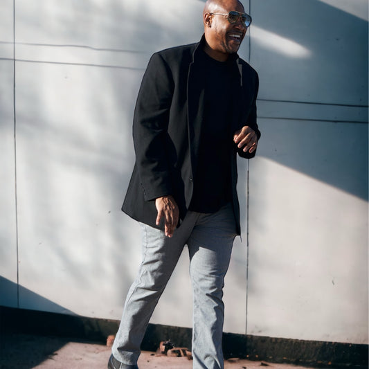 Avery Baker, the visionary behind Boss Ambitionz, walks with confidence in casual business attire, with the soft sunlight enhancing the optimistic mood of new beginnings and endless possibilities.