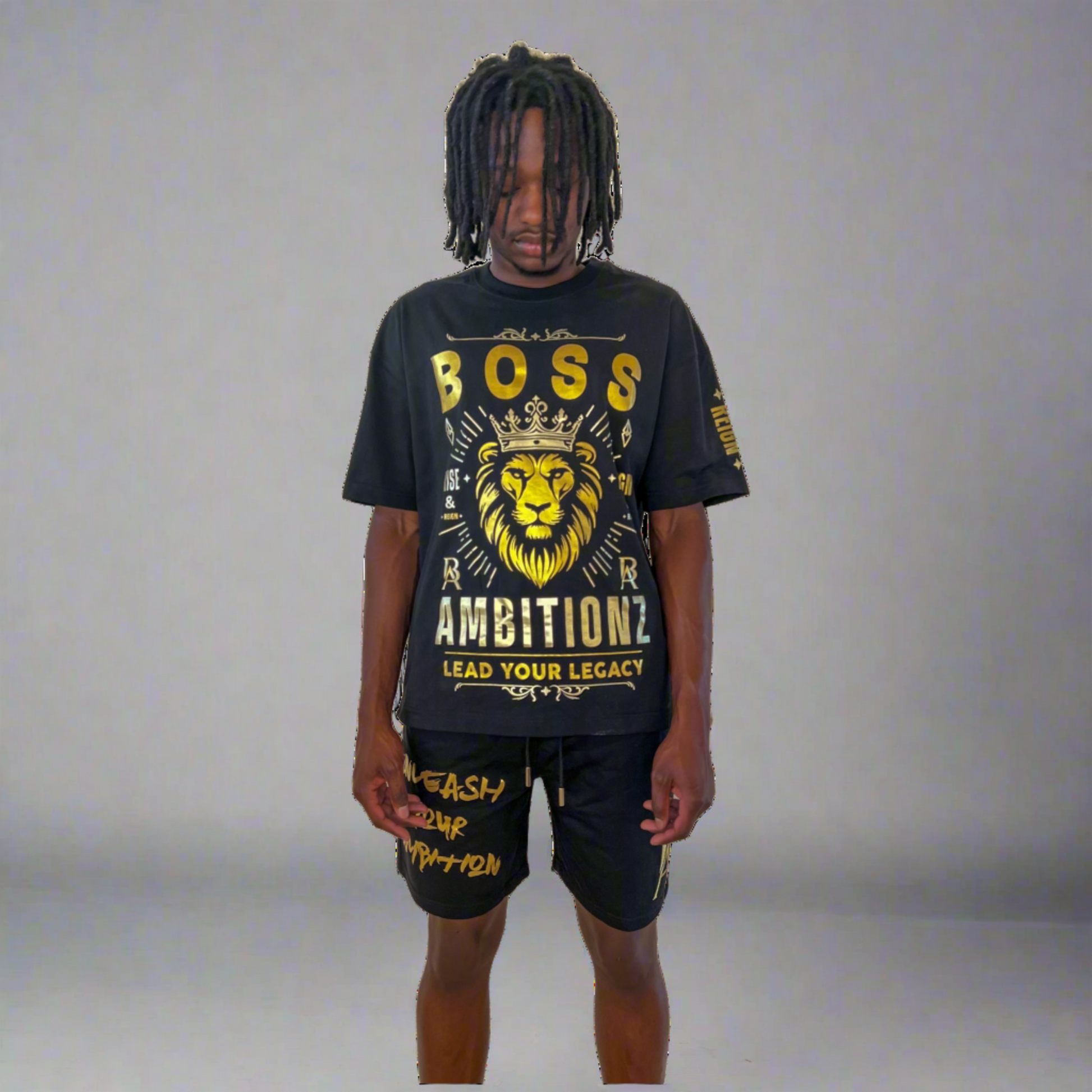 Front view of model wearing Boss Ambitionz outfit: "Model wearing a black Boss Ambitionz t-shirt with a bold lion design and 'Lead Your Legacy' slogan, paired with matching shorts featuring gold text detailing