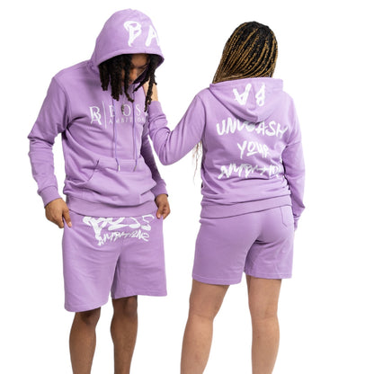 Paired to perfection, these two models embody the spirit of streetwear in the Street Heat Purple Haze Tracksuit Set. Their coordinated outfits, featuring the 'BOSS AMBITIONZ' logo on the hoodie and 'AMBITIONZ' on the shorts, showcase a unisex design that's both versatile and on-trend, making a strong statement about individuality and style