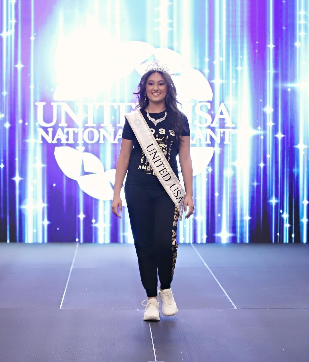 Rihana posing with elegance at the United USA National Pageant in Daytona Beach, FL. She is wearing the Regal Lioness Tee from Boss Ambitionz, along with her sash and crown, highlighting her poised and radiant demeanor