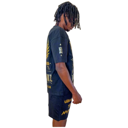 Side profile of model in Boss Ambitionz outfit: "Side profile of model wearing Boss Ambitionz t-shirt and shorts, emphasizing the intricate gold designs and motivational text 'Unleash Your Ambition' on the shorts.