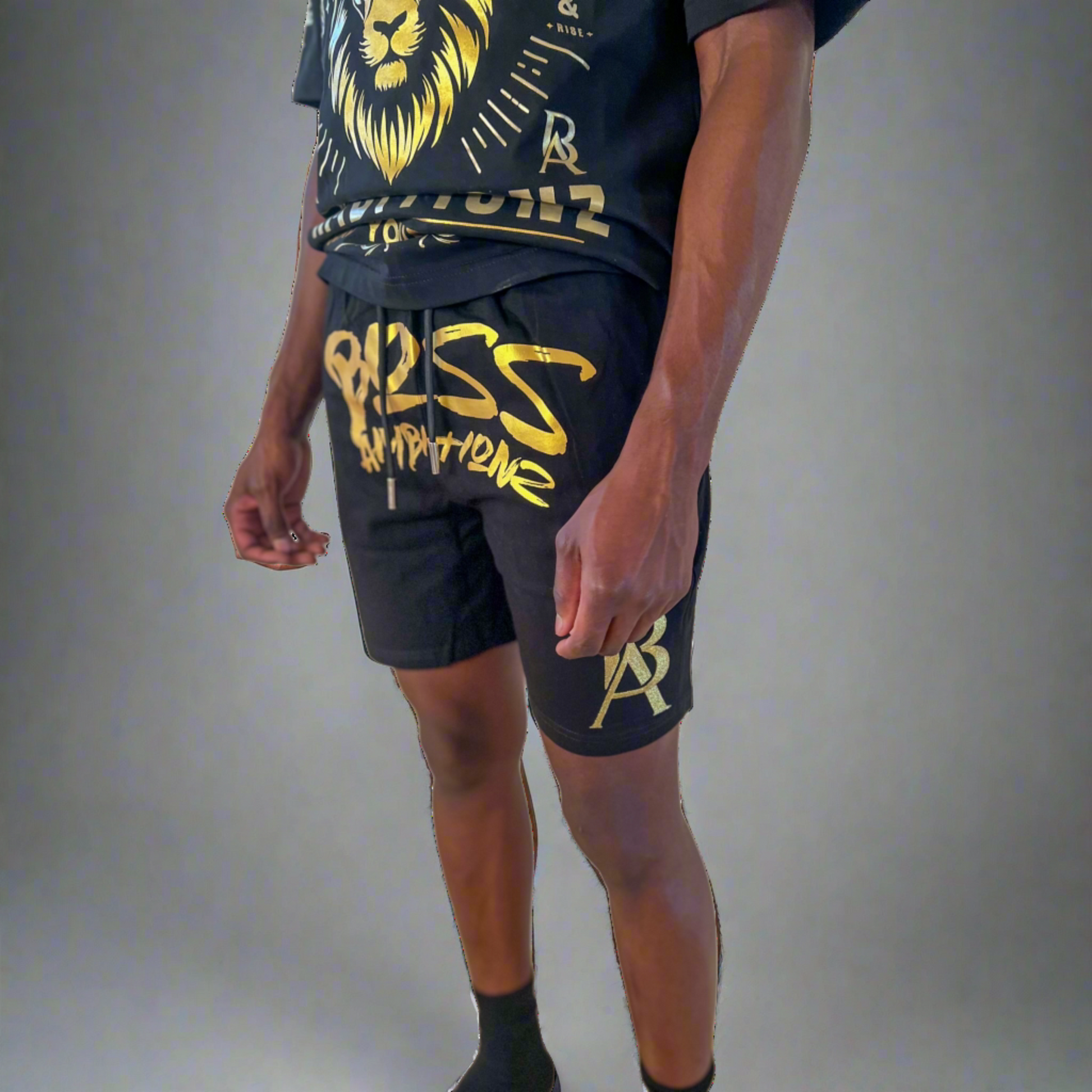 Close-up view of DaKidswagg in Boss Ambitionz shorts: "Close-up view of DaKidswagg wearing Boss Ambitionz shorts, highlighting the bold gold 'Boss Ambitionz' text and logo on the leg.