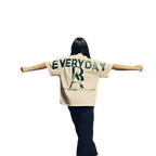 Rihanna showcasing the back of theBoss Ambitionz Everyday Luxe' Oversized Heavyweight Cotton Tee with both arms spread out. 