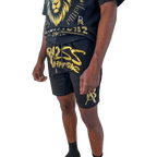 Close-up view of DaKidswagg in Boss Ambitionz shorts: "Close-up view of DaKidswagg wearing Boss Ambitionz shorts, highlighting the bold gold 'Boss Ambitionz' text and logo on the leg.