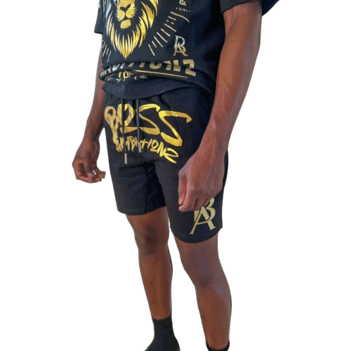 Close-up view of DaKidswagg in Boss Ambitionz shorts: "Close-up view of DaKidswagg wearing Boss Ambitionz shorts, highlighting the bold gold 'Boss Ambitionz' text and logo on the leg.